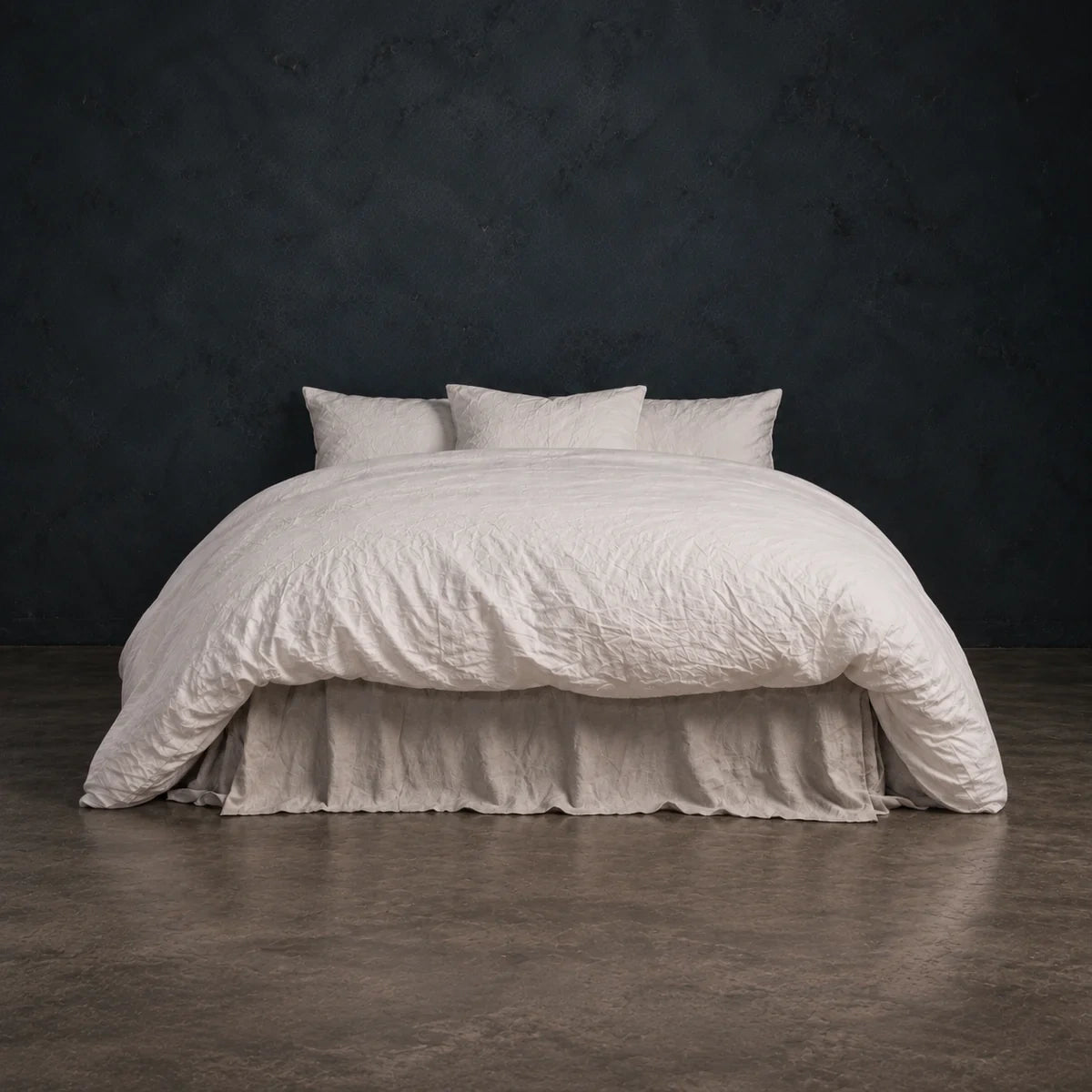 Cloud Heaven Duvet draped over a bed against a dark wall.
