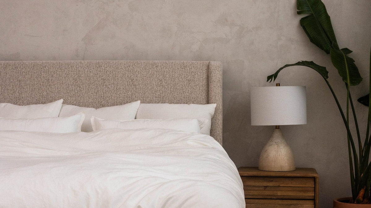 Made bed with a fluffy white cloud duvet and pillows, front view