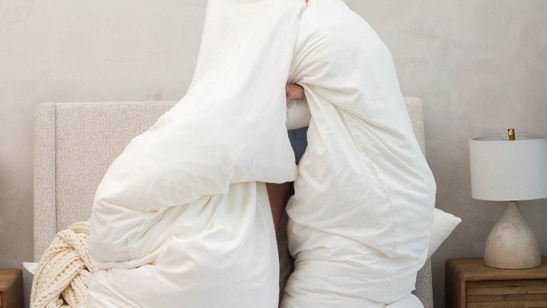 Woman holding up a lofted cloud duvet in a bedroom to show its fluff