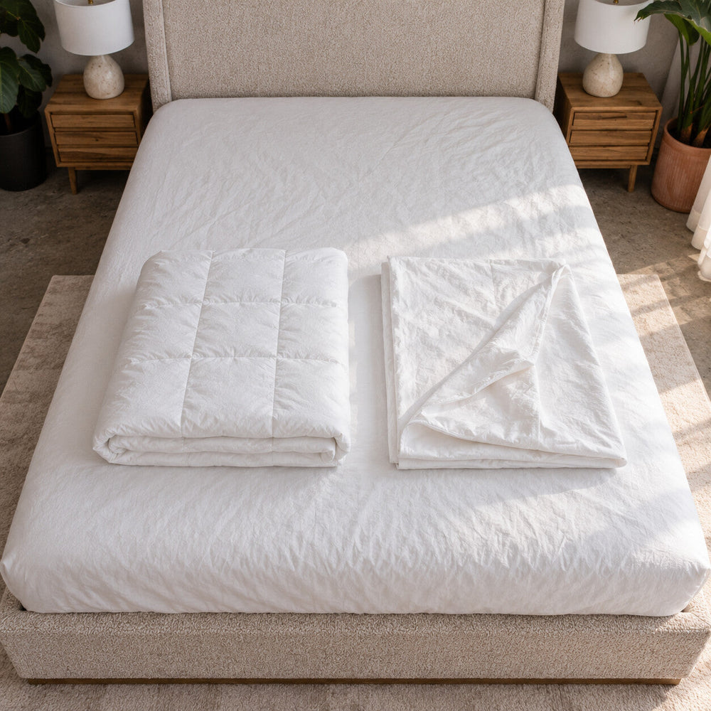 Air Duvet Set made up on an upholstered bed in a sunlit bedroom, the lightweight duvet in its white cotton cover