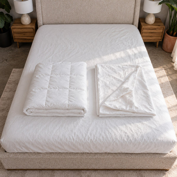 The two pieces of the Air Duvet Set folded on a bed: the quilted Air duvet and its matching empty cotton percale cover