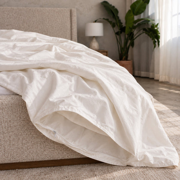 The empty Cloud Duvet Cover opened and draped over the corner of a bed, with no filling inside