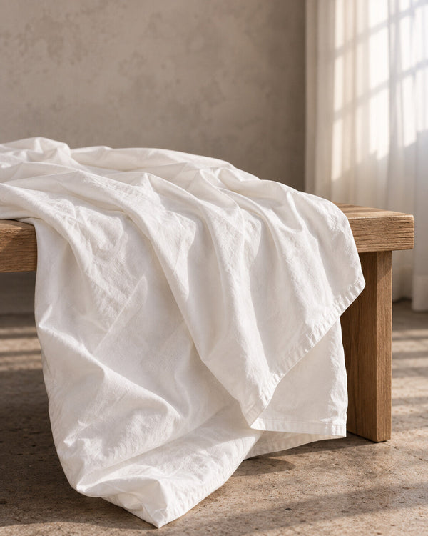 The Cloud Duvet Cover draped over a wooden bench, showing the soft, matte percale weave