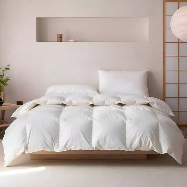 A white goose down duvet on a made bed, shown without its cover