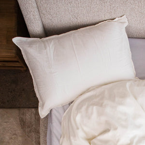 A white cotton percale Cloud Pillowcase on a pillow at the head of a bed, seen from above