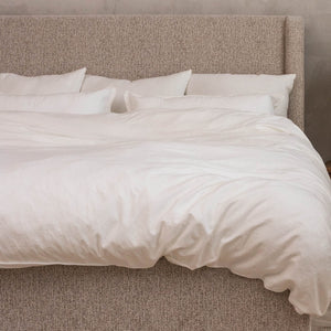 Cloud Pillows against an upholstered headboard on a bed made with a white duvet