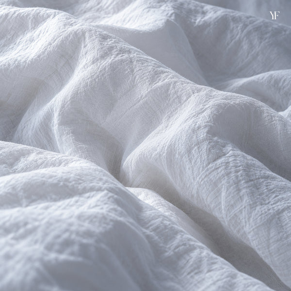 Close view of the Cloud Duvet Cover's white cotton percale, softly rumpled over a filled duvet