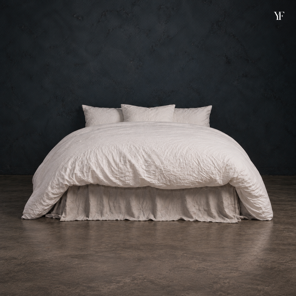 Front view of the white Heaven duvet on a bed, with pillows and a softly draped bed skirt.