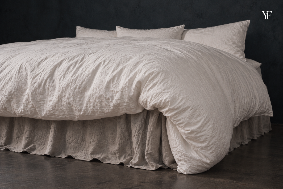 The rounded corner of a white Cloud duvet drapes over the side and foot of a bed.