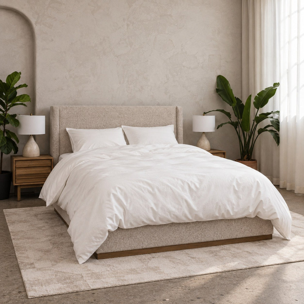 The Cloud Duvet Set on a bed seen from the foot corner: a lofty white duvet in its matching cotton cover, with two white pillows