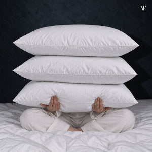 Three white Cloud Pillows stacked in a seated person's arms.